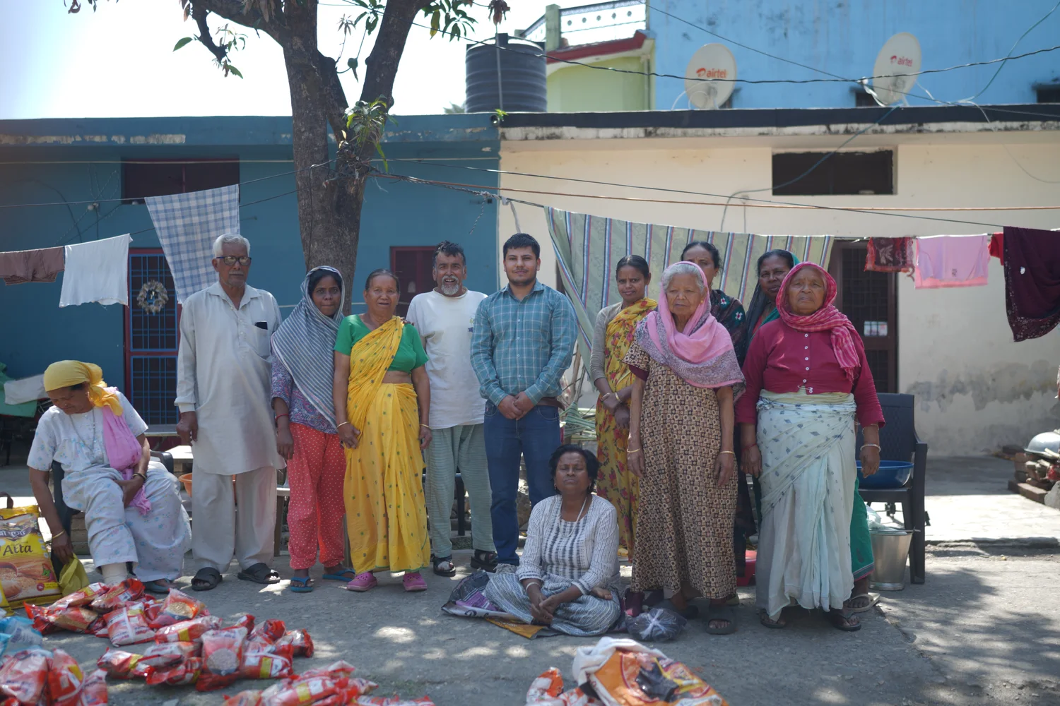 Community members and the Dev Bhoomi Samiti team beside assistance supplies