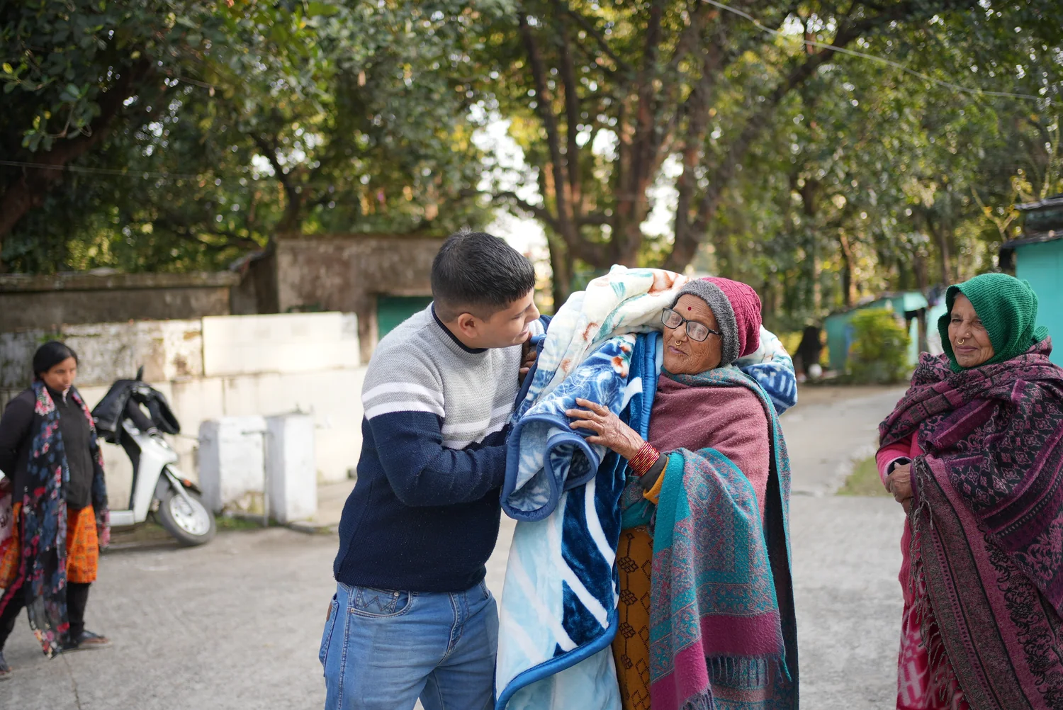 An older resident receives a blue blanket during winter outreach.