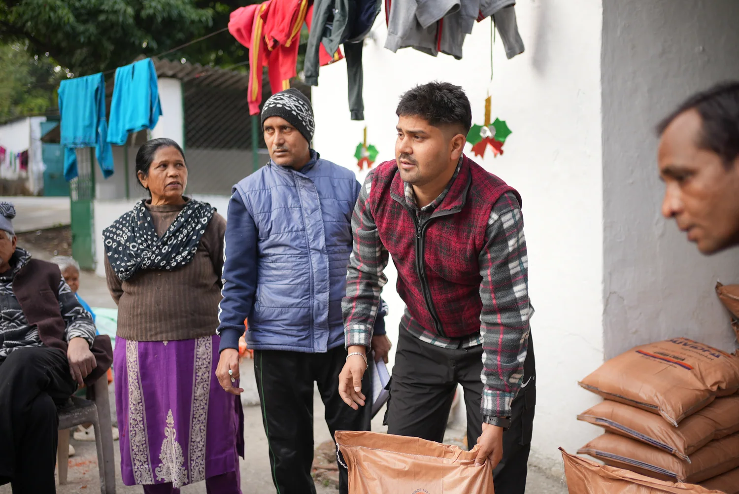 Team members stand beside stacked ration bags during the winter distribution.