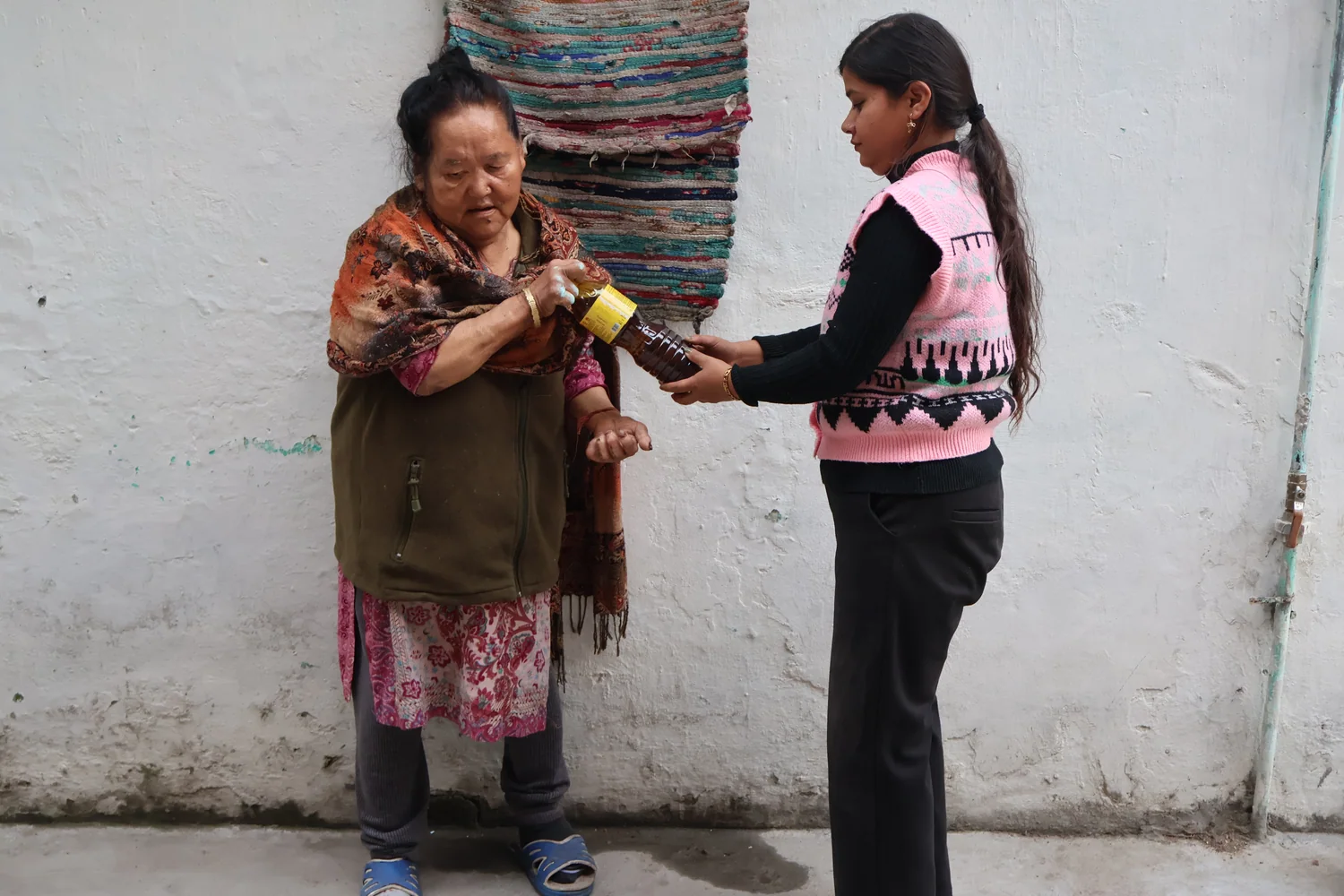 Cooking oil is handed to a woman during the ration-support activity.