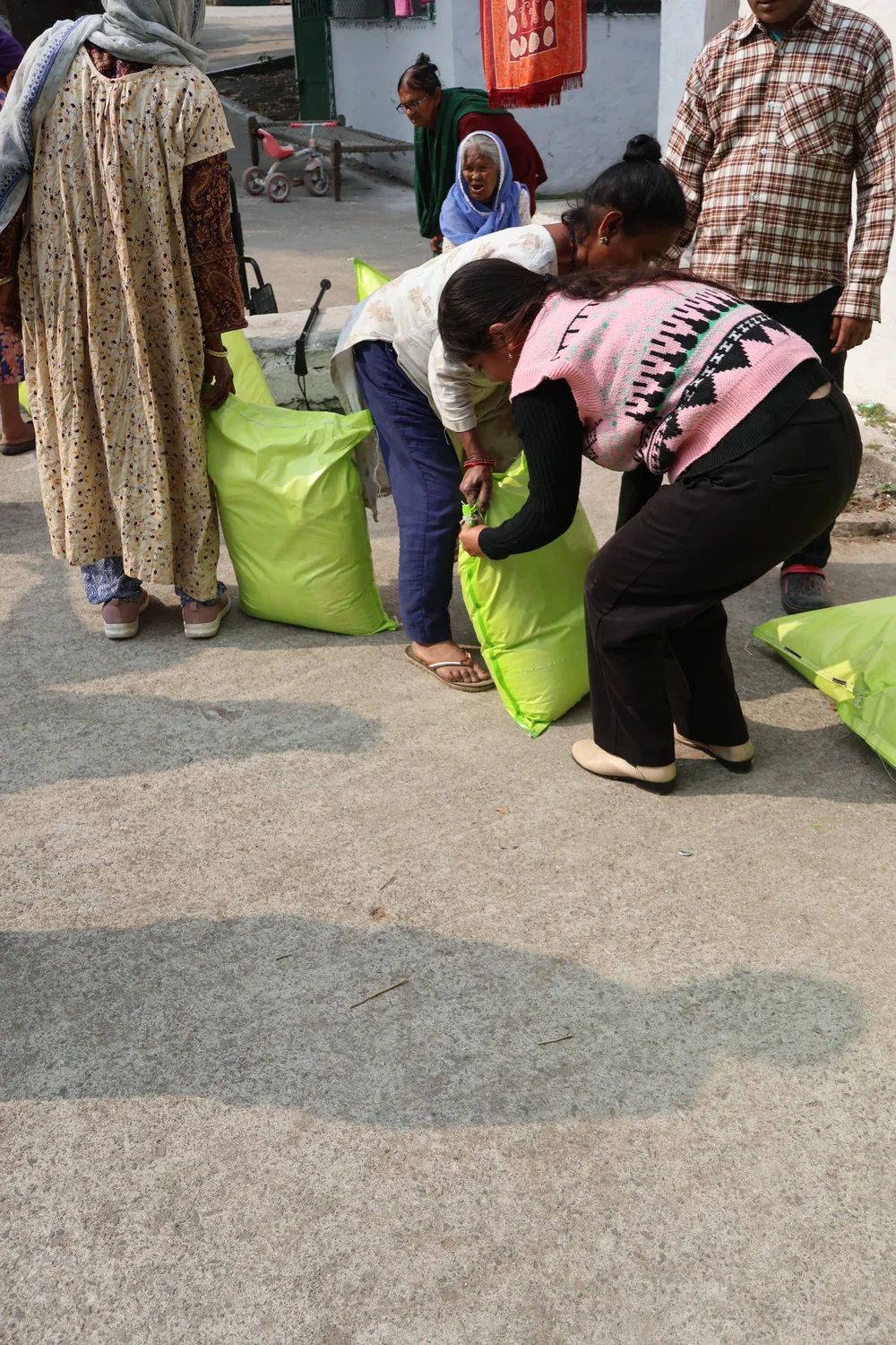 Hands-on assistance with lifting a ration bag from the distribution area.