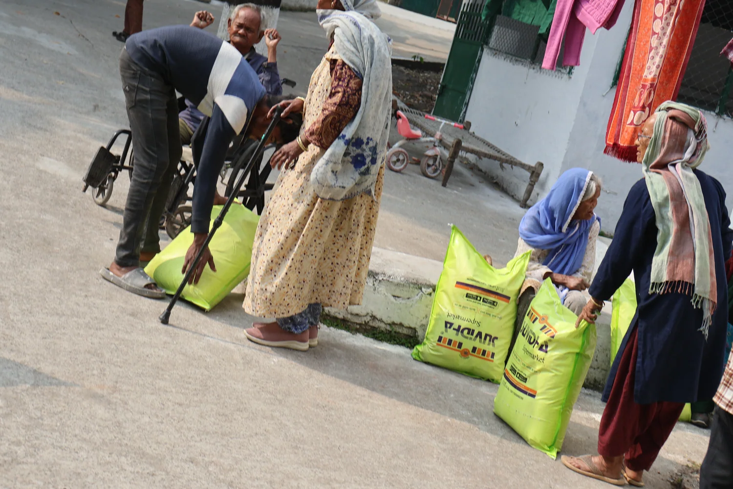 Older residents receive practical help as ration supplies are collected.