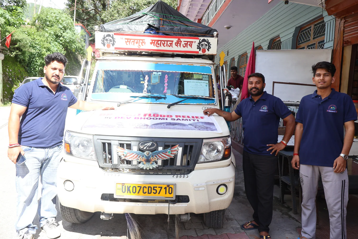 Team members beside a vehicle prepared for the Dharali relief programme.