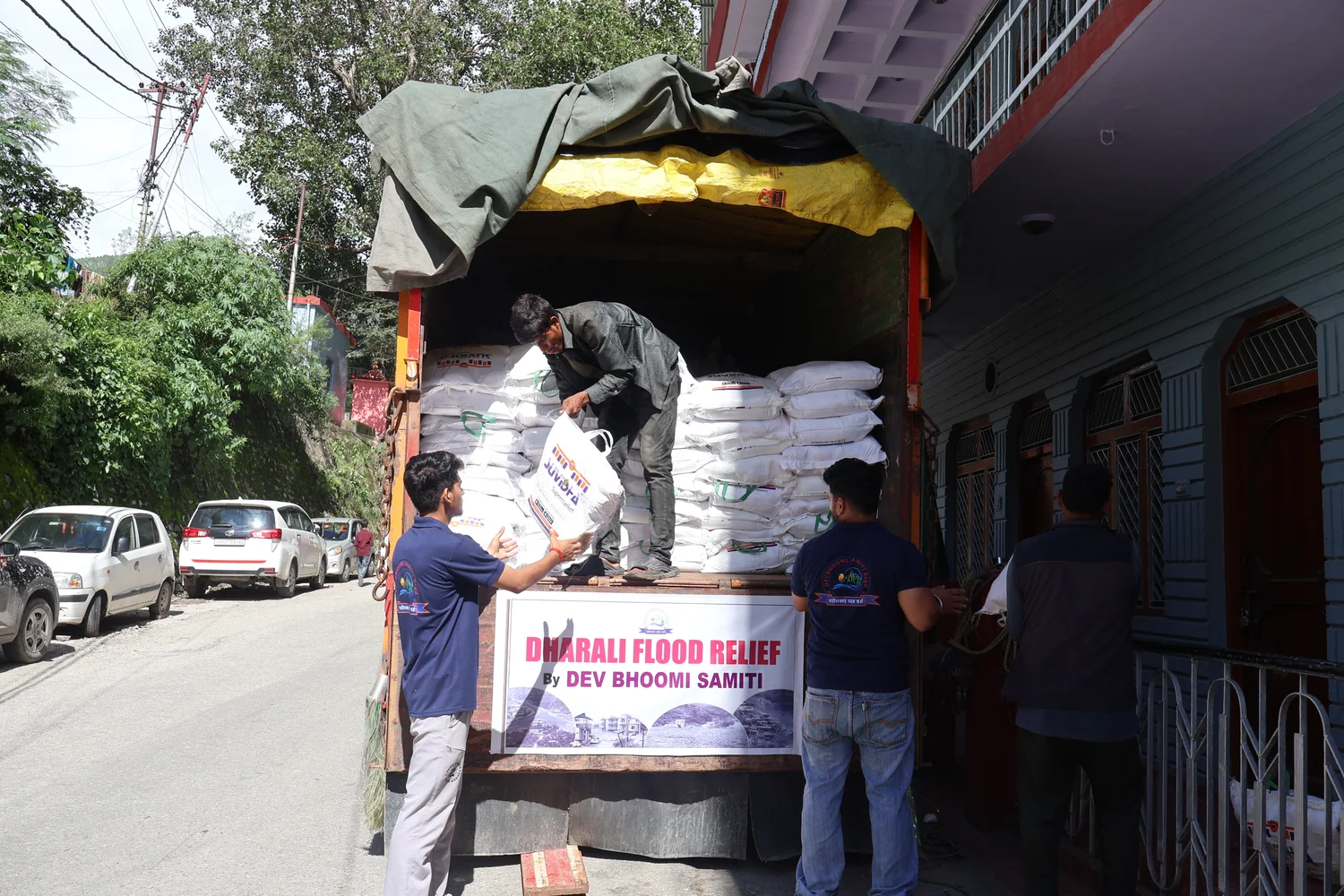 A truck loaded with ration sacks and marked with a Dharali flood relief banner.
