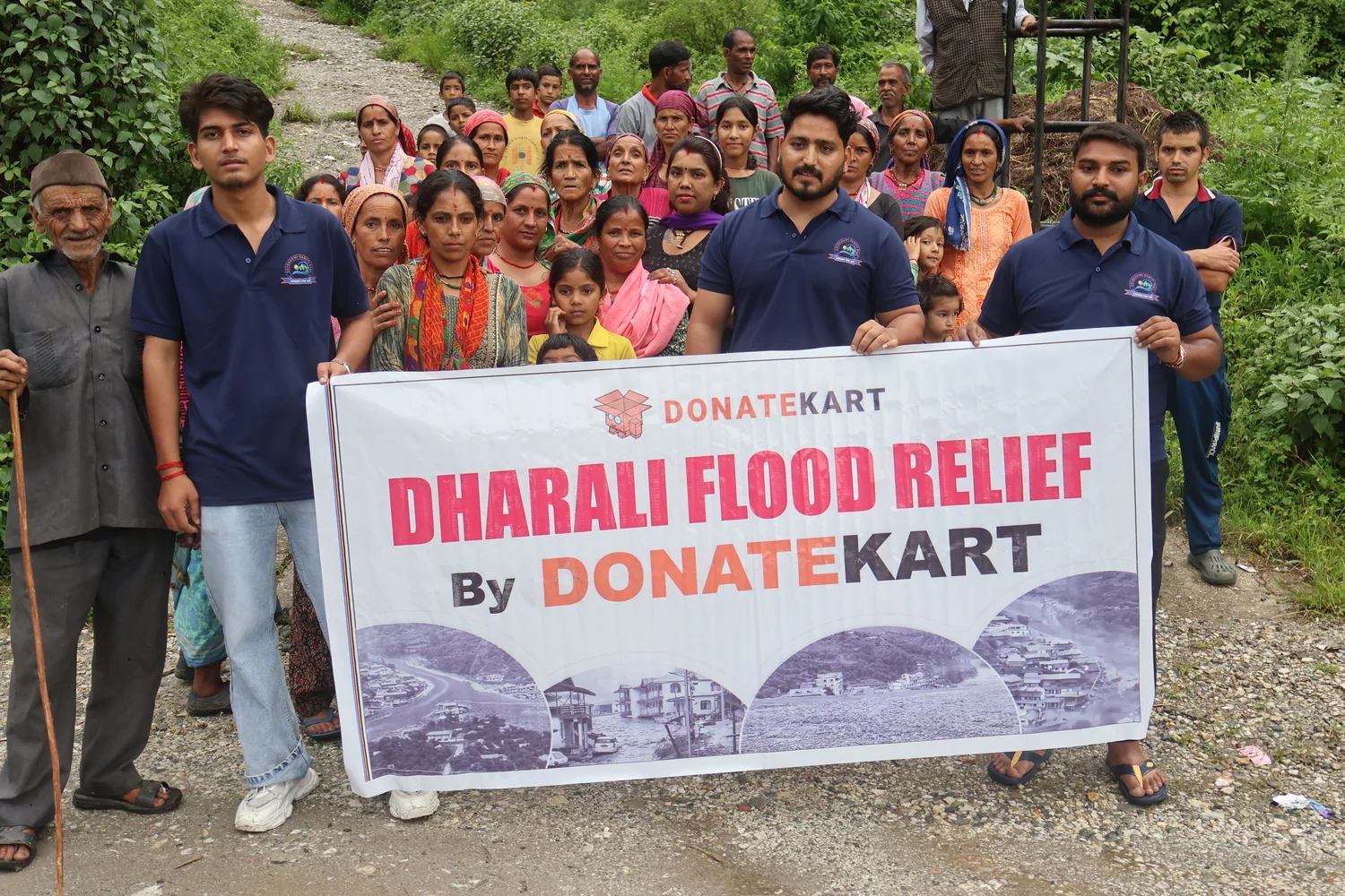 Community members and the team gather with a Dharali relief banner.