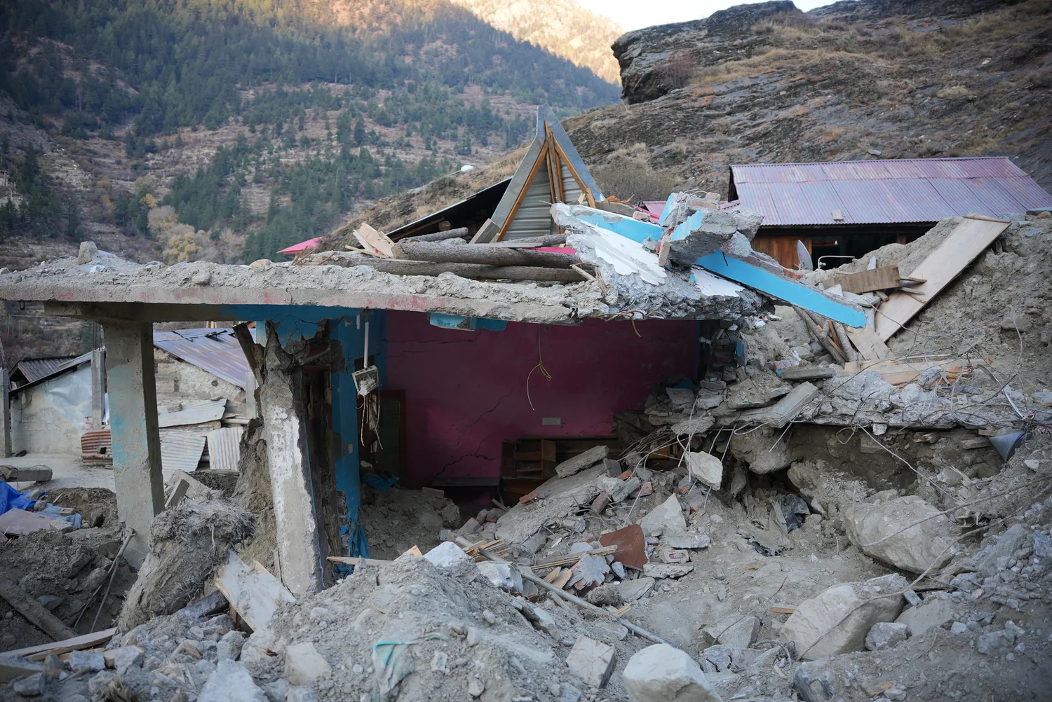 A damaged building among rock and earth deposits.