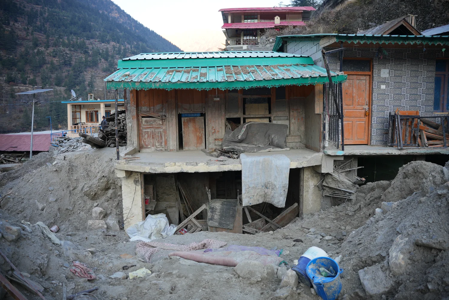 A building exterior and disrupted ground in the recovery area.
