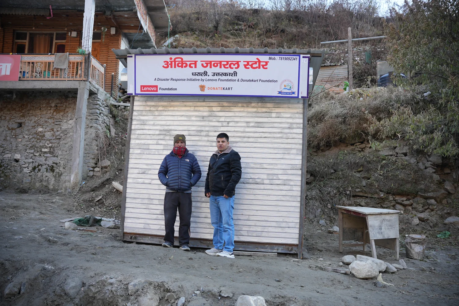 People beside another shop unit and its programme signage.