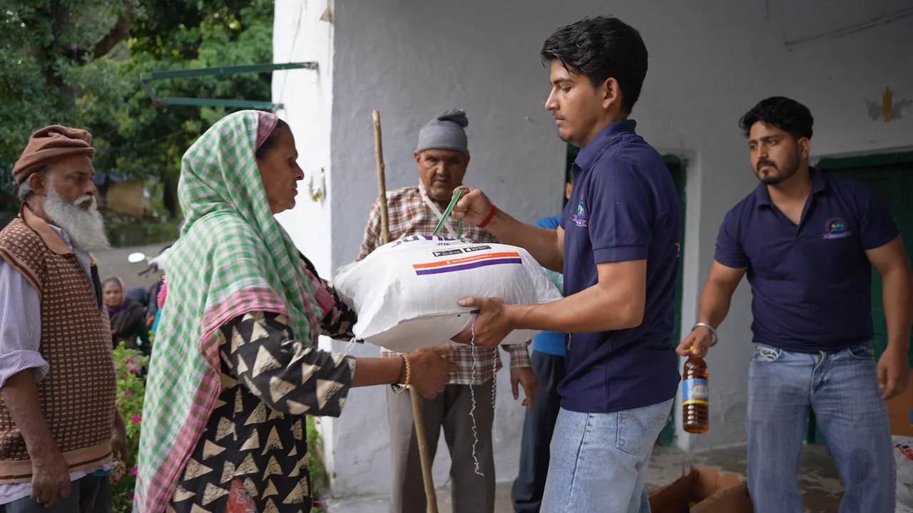 Ration supplies are handed to residents during an outdoor visit.