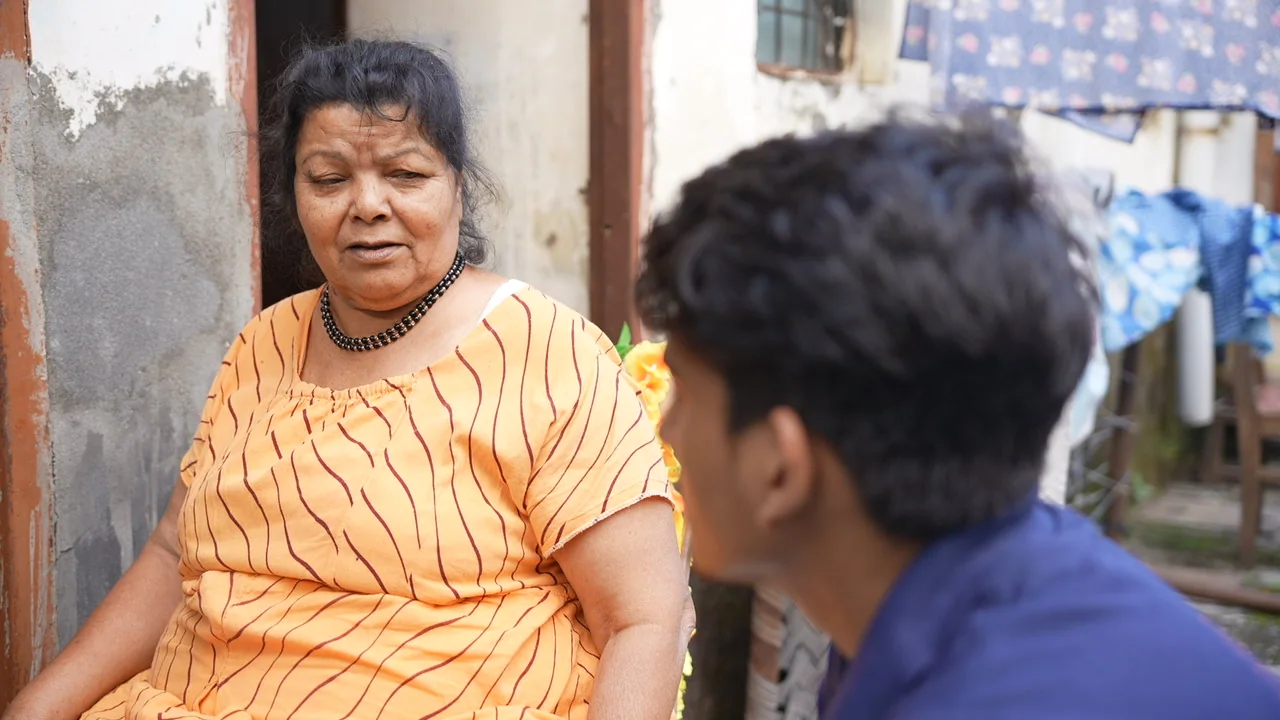 A team member listens to an older woman during a neighbourhood visit.