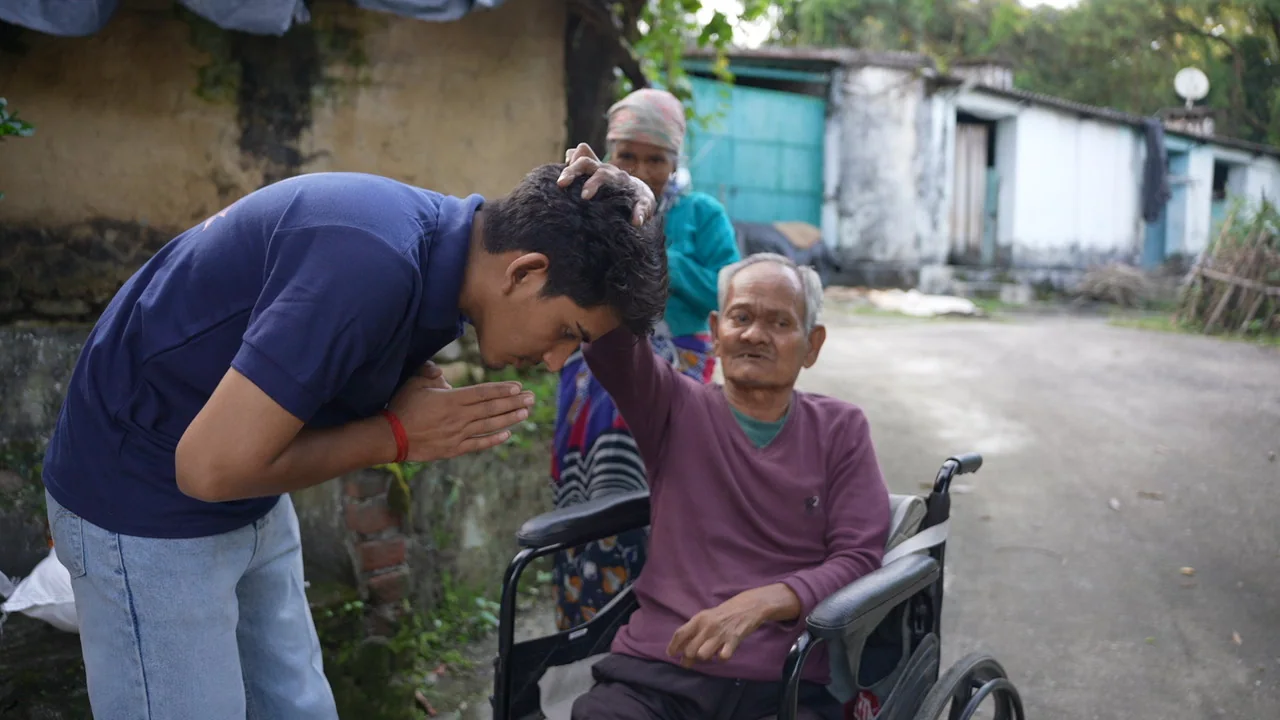 A personal greeting with an older woman seated in a wheelchair.