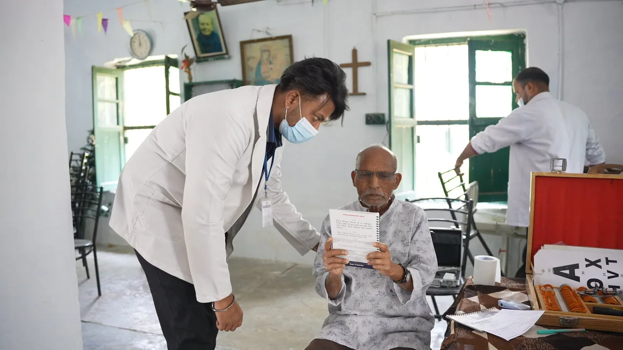 A seated resident receives attention from the health team.