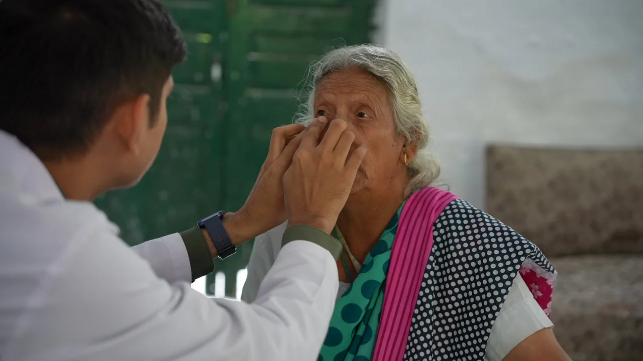 A member of the eye-care team examines an older resident.
