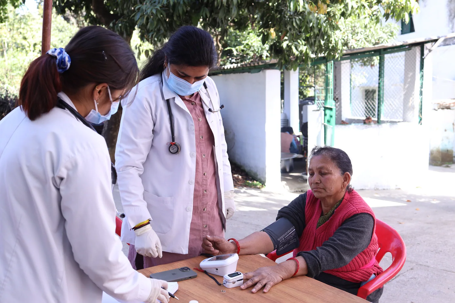 An older resident meets the health team at a consultation table.
