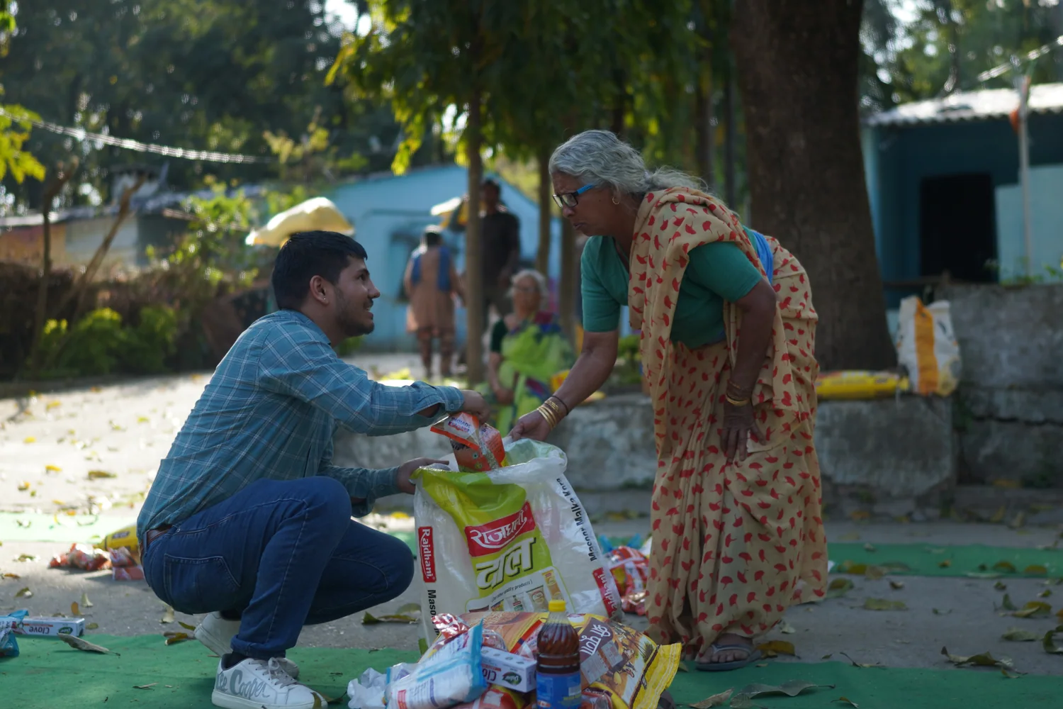 A team member helps a resident collect her ration supplies.