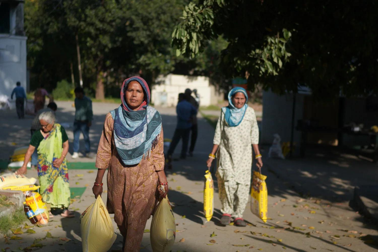 Residents carry bags of supplies away from the handover area.