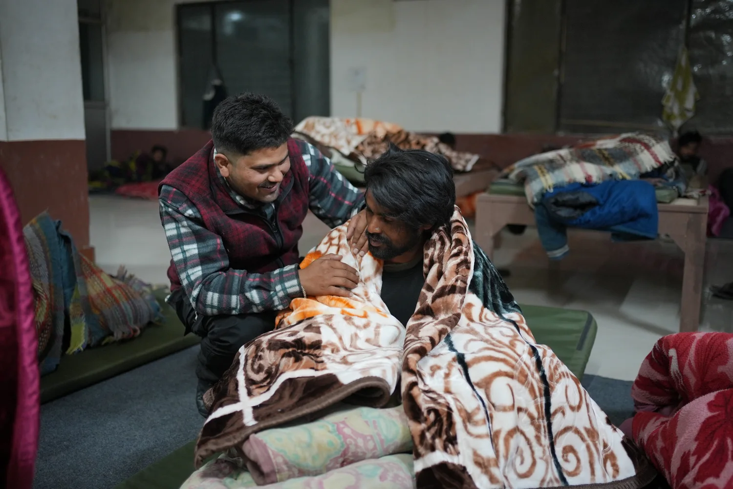 A patterned blanket is arranged around a shelter resident.