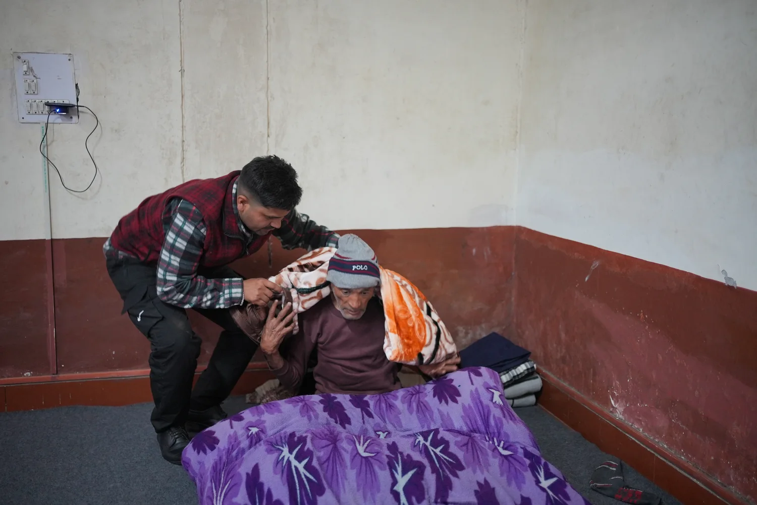 A team member sits beside a resident during the winter outreach visit.
