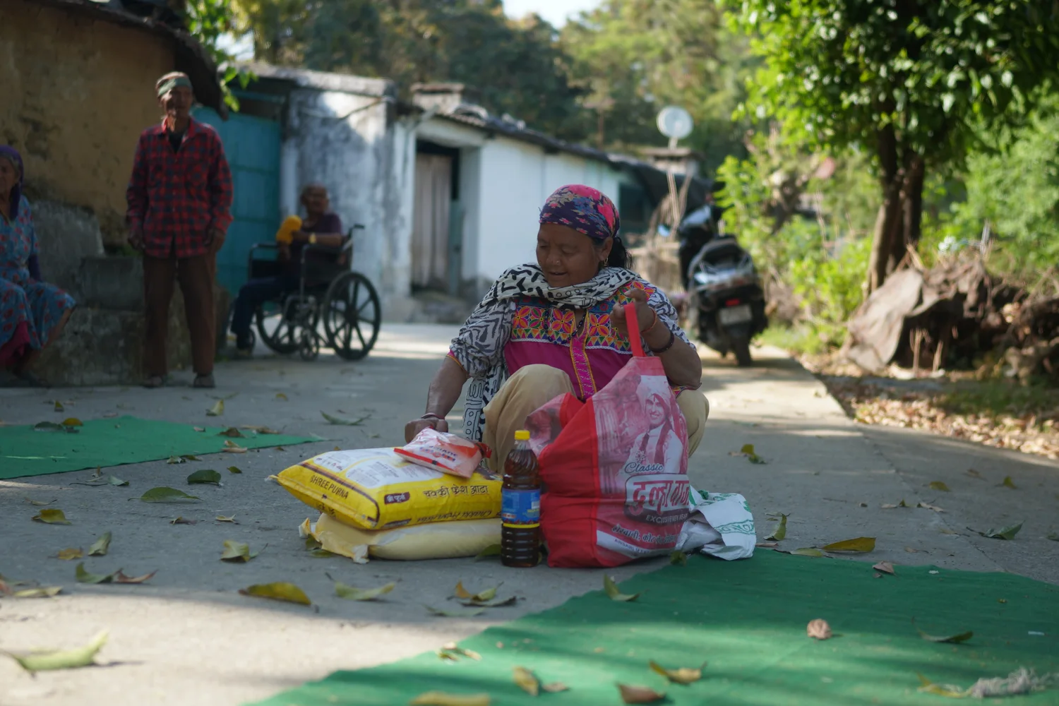A resident waits beside a ration bag in the distribution area.