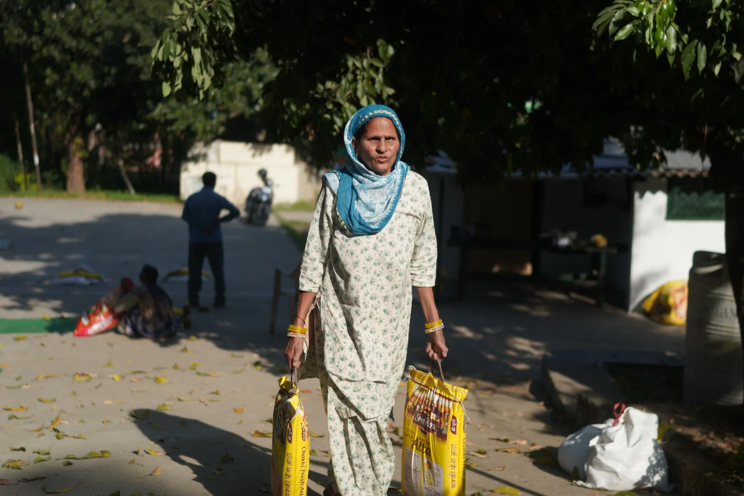 A resident stands with collected supplies after the community handover.