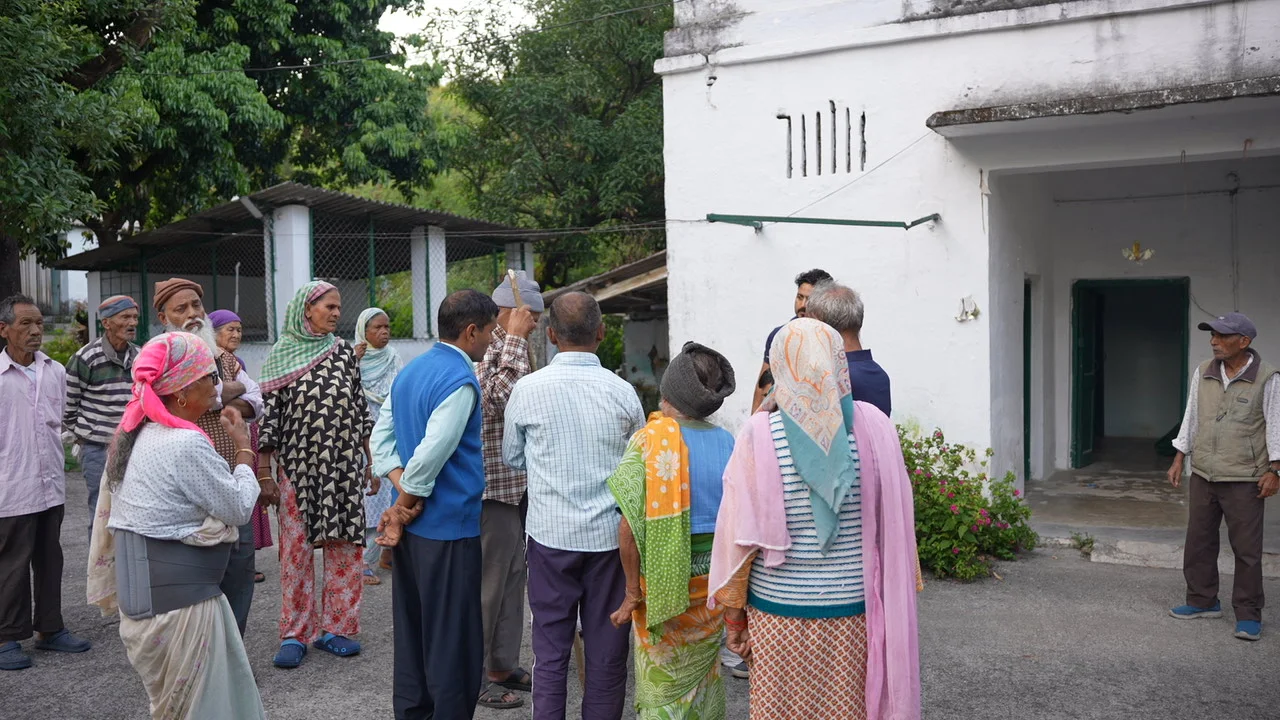 Residents and visitors gather near a community building.