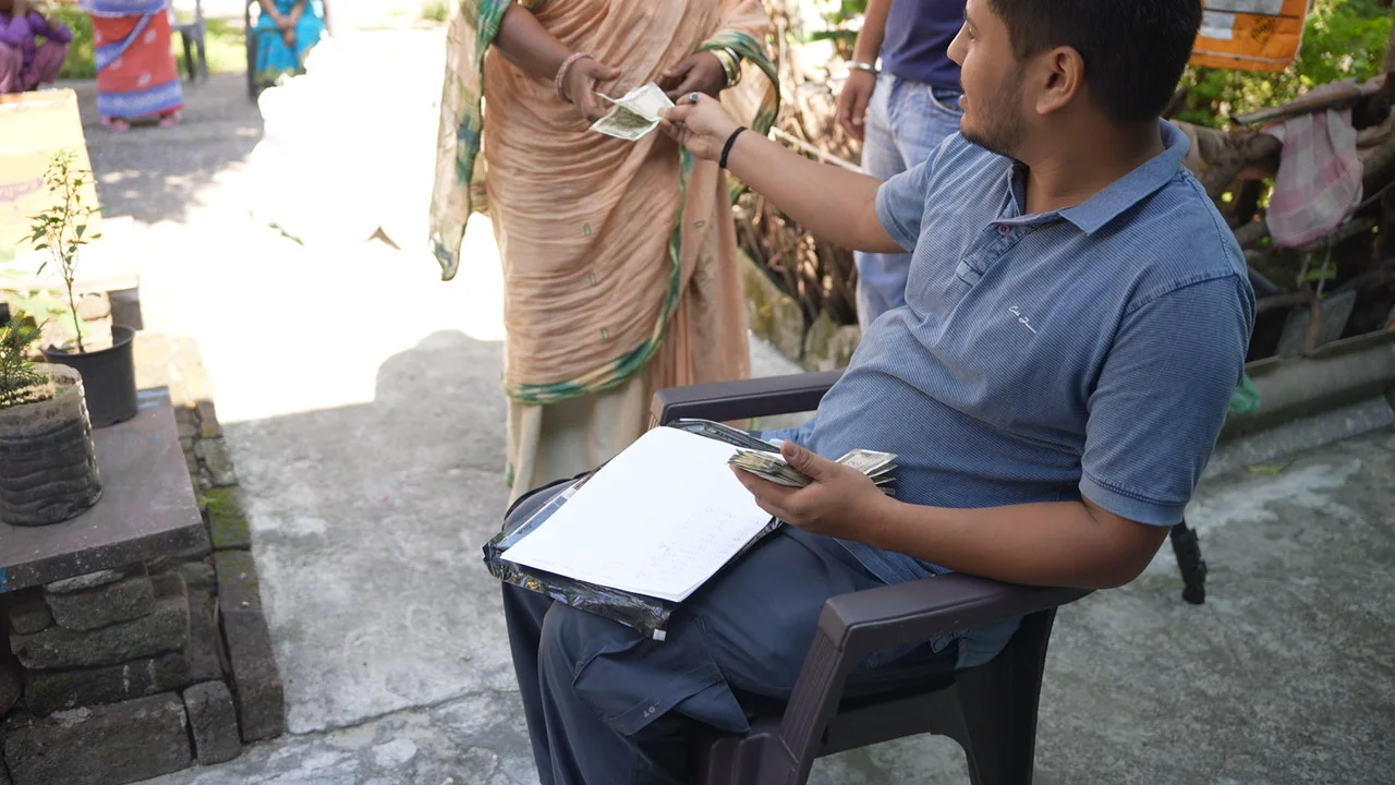 A seated team member listens to a resident in the community.