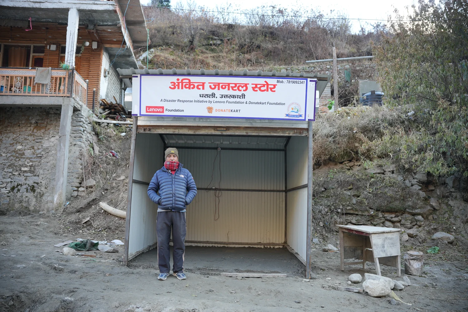 A person stands inside a small shop structure.