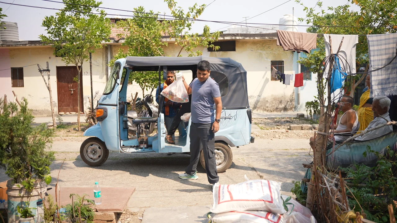 A team member stands beside a vehicle used to bring supplies into the neighbourhood.