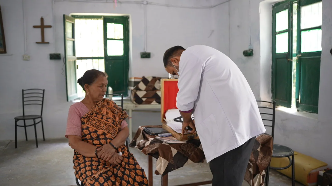 A resident meets a member of the eye-care team at a consultation table.