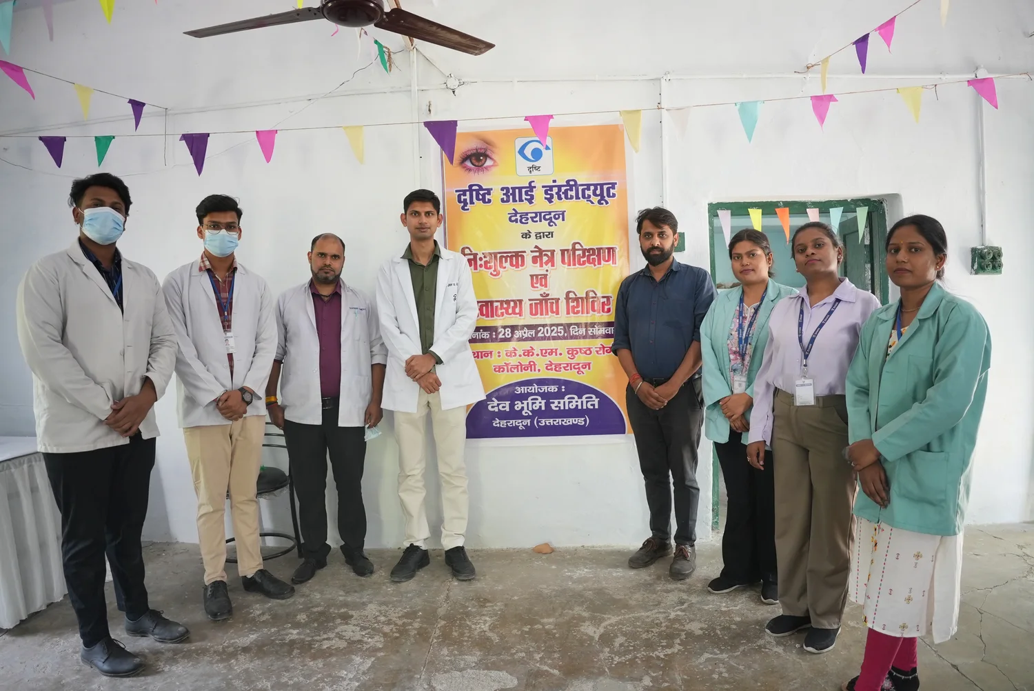 The outreach team stands together beside the health-session banner.