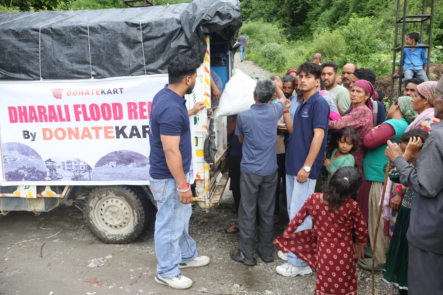 Residents speak with the team beside the relief vehicle.