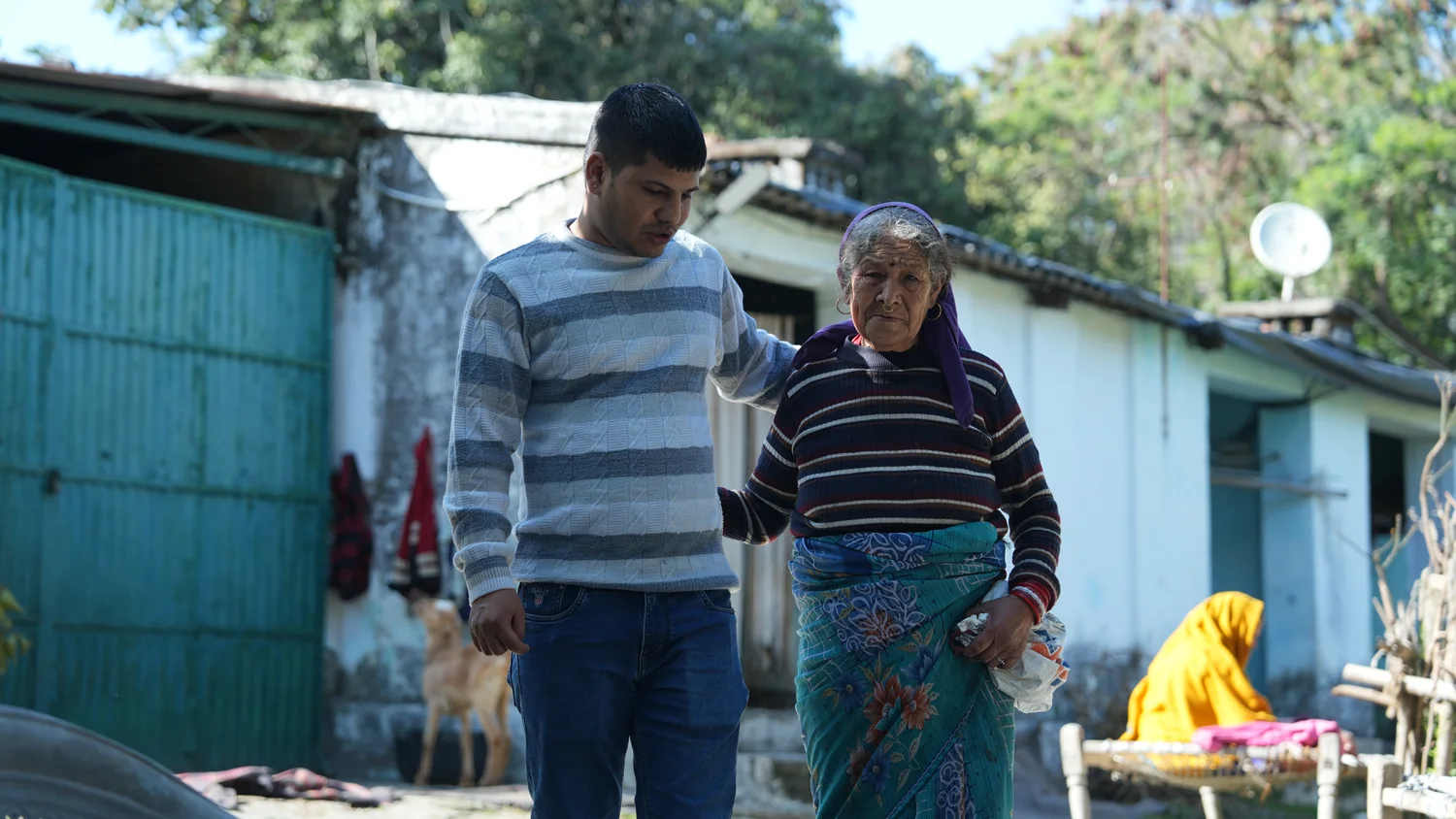 A team member walks alongside an older woman in the neighbourhood.