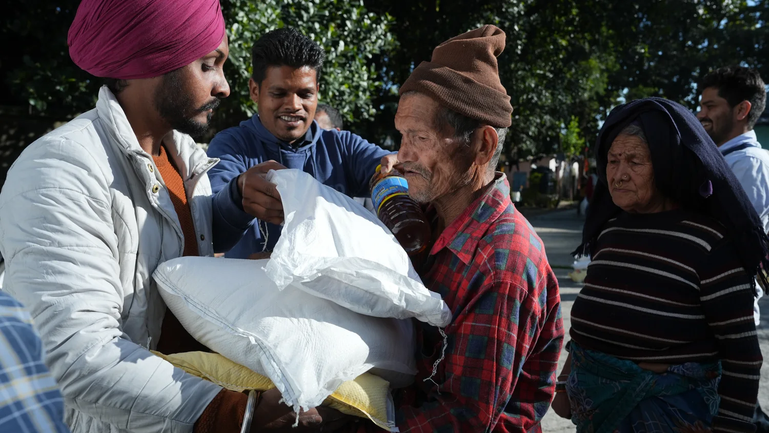 A sack of supplies is handed to an older resident during the gathering.