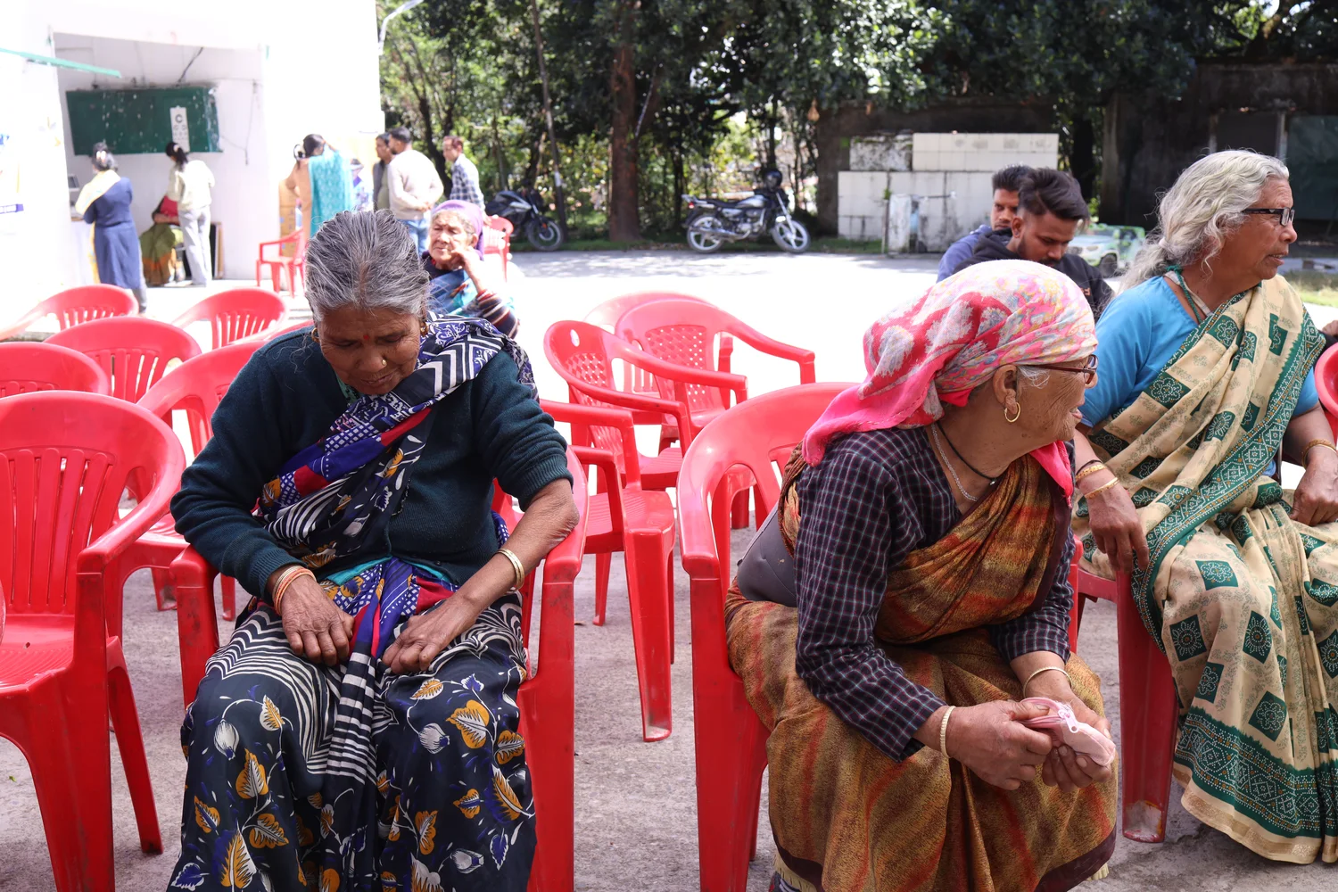Residents sit in the outdoor waiting area during the session.