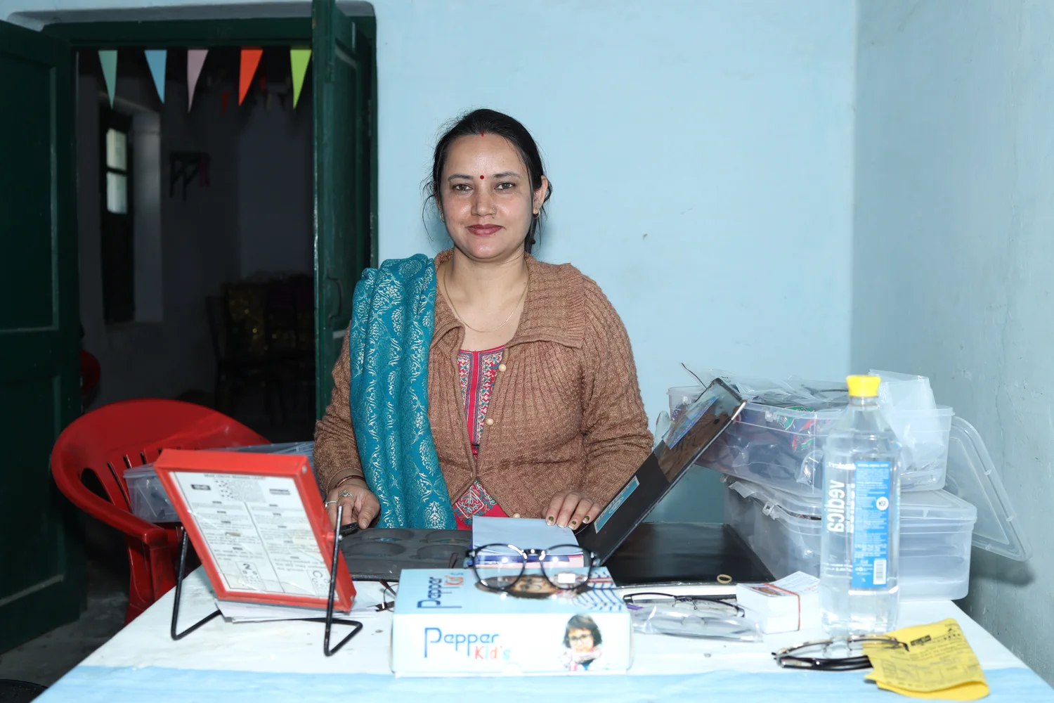 A team member seated beside consultation equipment.