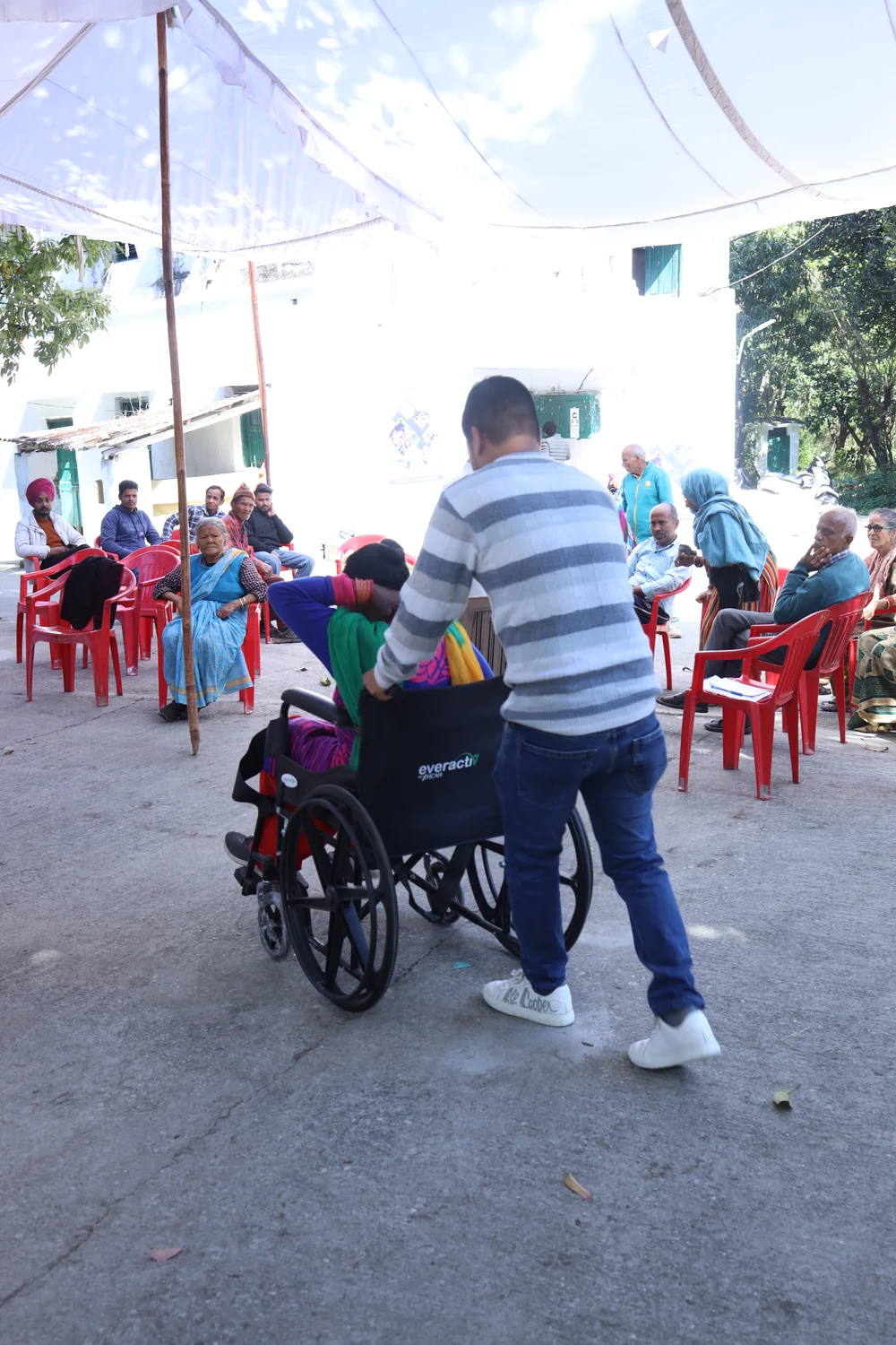 A team member assists a wheelchair user through the outreach area.
