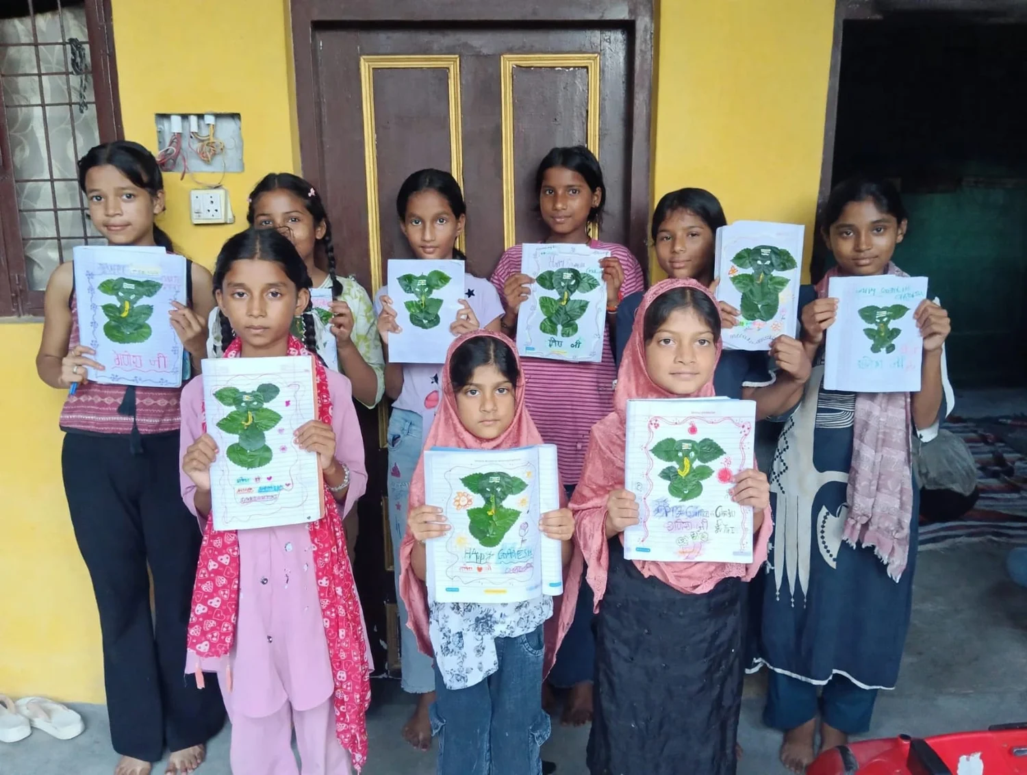 A group of learners display their leaf artworks together.