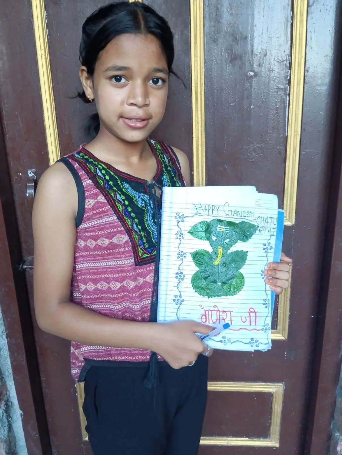 A learner presents her completed leaf artwork and handwritten festival greeting.