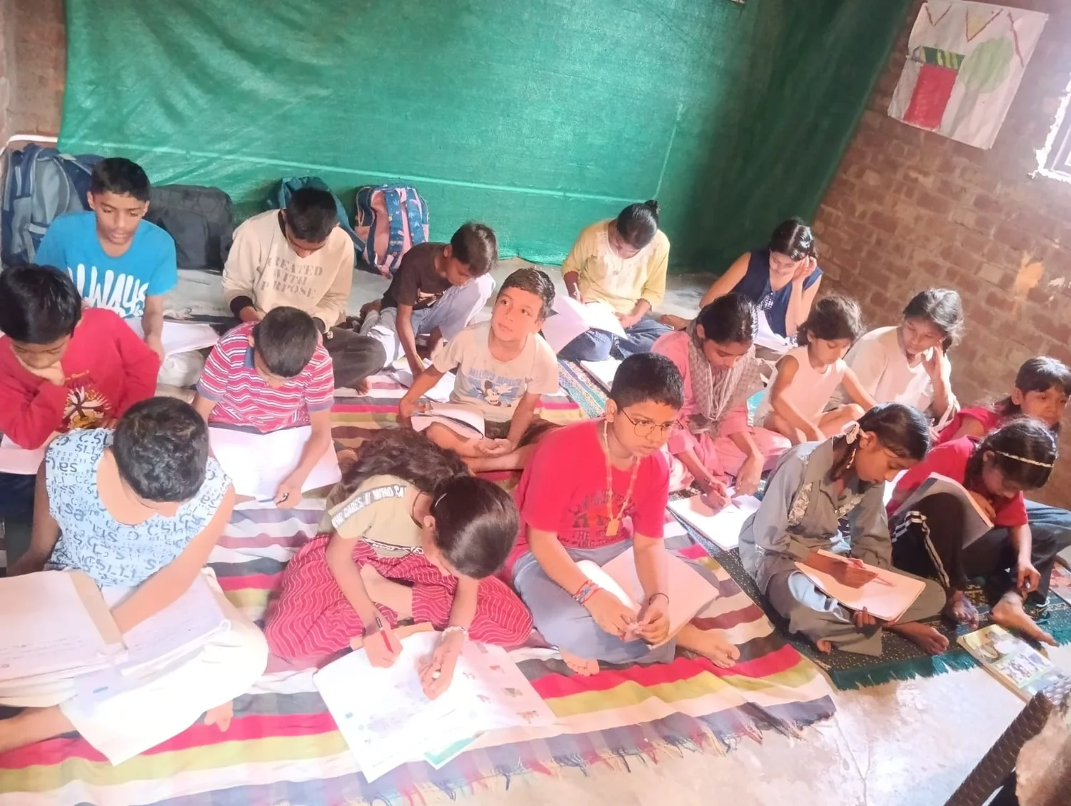 A wide view of children working on individual notebooks in the learning room.
