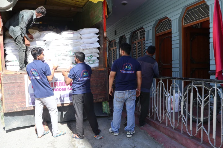 Dev Bhoomi Samiti team standing behind a loaded Dharali flood relief truck