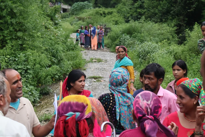 Community members gathered on a hillside path during relief distribution