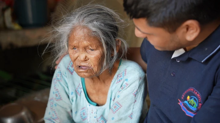 An older woman speaking with a Dev Bhoomi Samiti volunteer
