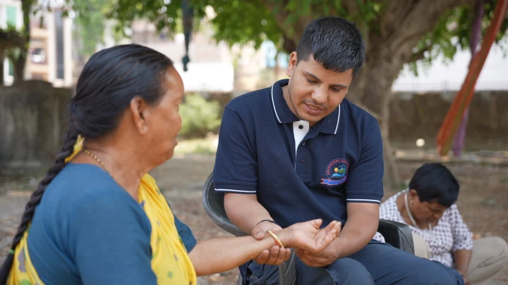 Dev Bhoomi Samiti volunteer speaking with a woman during a community visit