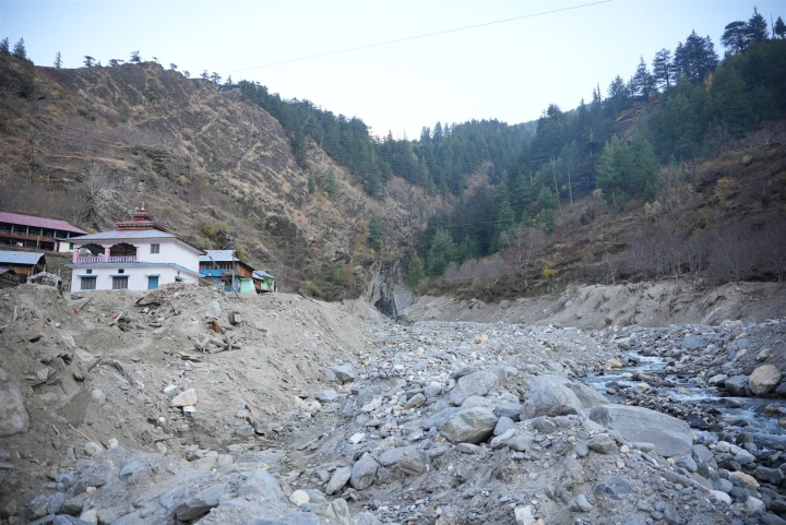 Rocky riverbed and buildings in a mountain valley in Uttarakhand