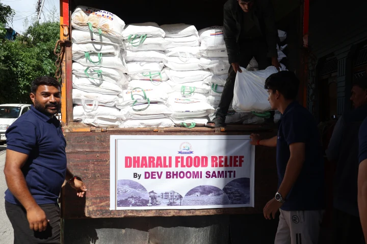 A volunteer beside a truck filled with Dharali flood relief supplies