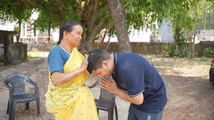 A volunteer greeting an older woman during a community visit
