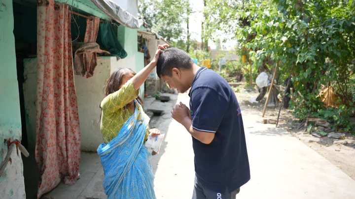 A volunteer greeting a woman in a community lane