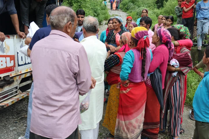 Residents gathered beside the Dev Bhoomi Samiti relief distribution vehicle