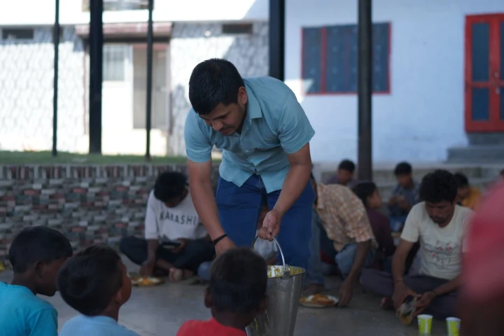 Children receiving food from a volunteer during a shared meal
