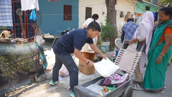 A volunteer arranging supplies beside community residents